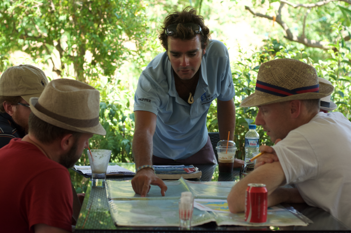 A expert local skipper from Sail Ionian offers advice during a route plan ashore before charter guests set sail