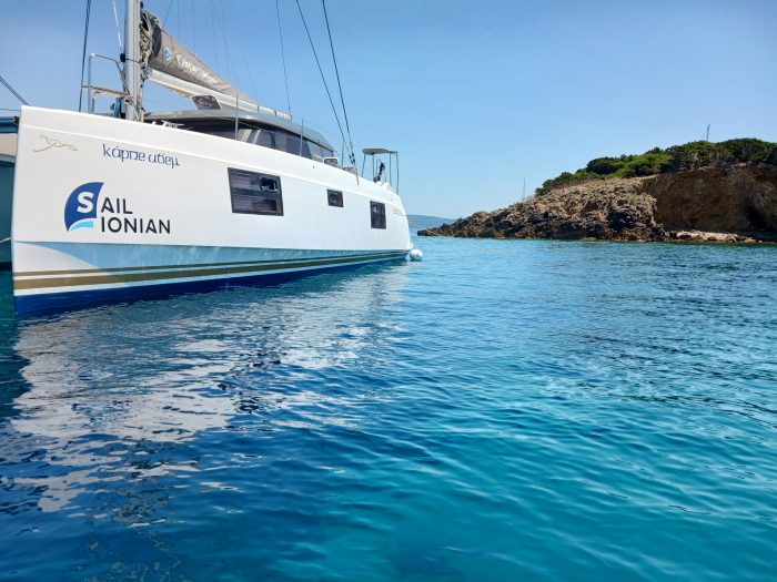 A large white Open 40 catamaran named 